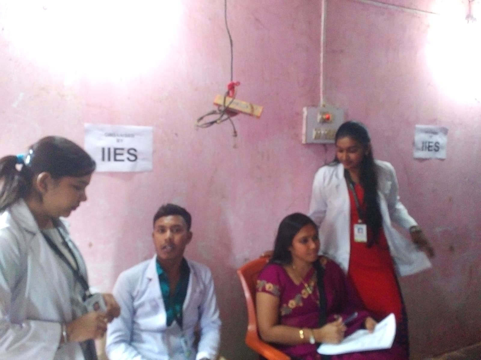 IIES volunteers in white coats at a village health screening camp