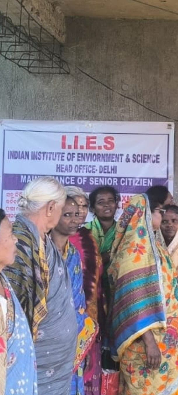Elderly residents at an IIES senior citizens programme beneath the programme banner